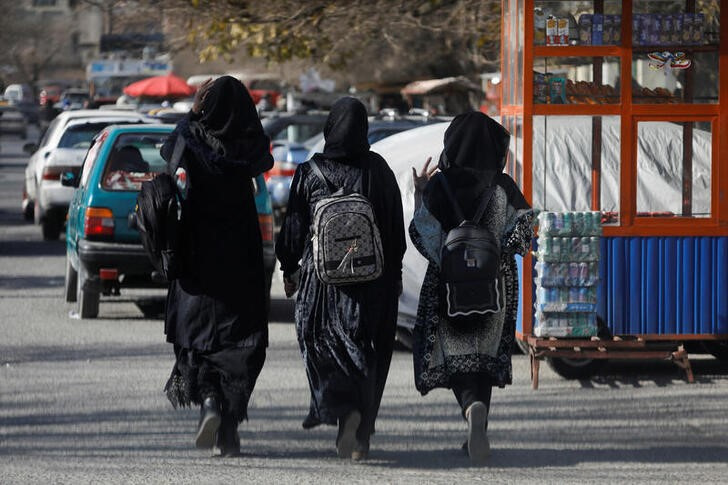 Estudiantes afganas caminan con sus mochilas cerca de la Universidad de Kabul, Afganistán.
